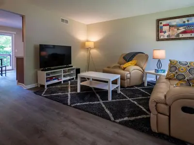 a living room with two couches and a flat screen tv at Lovely West Akron home with attached private garage in Akron
