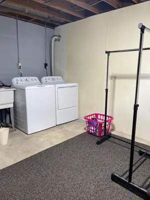a laundry room with two washing machines and a basket at Lovely West Akron home with attached private garage in Akron