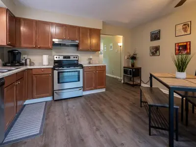 a kitchen with wooden cabinets and a stove and a table at Lovely West Akron home with attached private garage in Akron