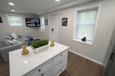 a living room with a couch and a white counter at Brand new first floor studio in quiet neighborhood in Akron