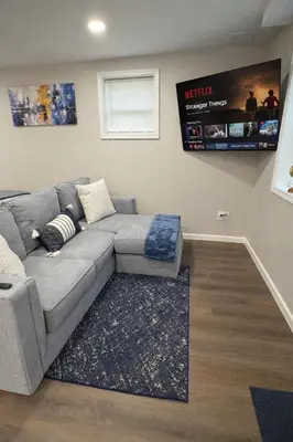 a living room with a couch and a tv at Brand new first floor studio in quiet neighborhood in Akron