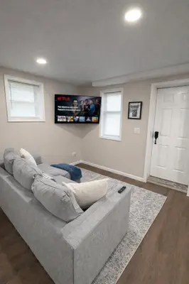 a gray couch in a living room with a door at Brand new first floor studio in quiet neighborhood in Akron