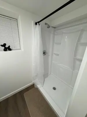 a white shower in a bathroom with a window at Brand new first floor studio in quiet neighborhood in Akron