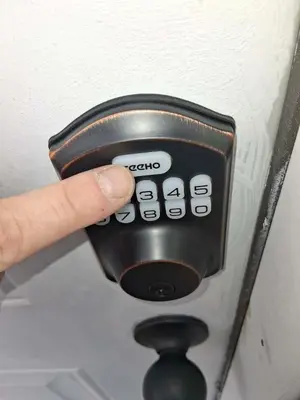 a hand holding a remote control in a room at Cosy single-level home with laundry and parking in Huntington