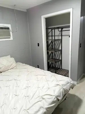a bedroom with a white bed and a closet at Cosy single-level home with laundry and parking in Huntington