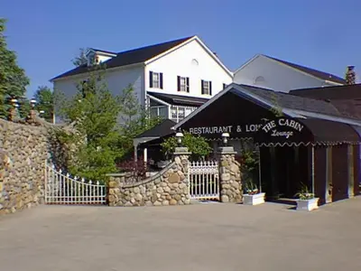 a building with a gate in front of a house at Mario's International Spa, Hotel & Restaurant in Aurora