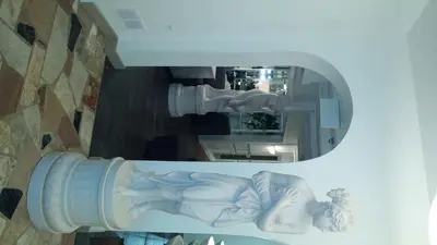 a mirror with a statue of a baby in a room at Mario's International Spa, Hotel & Restaurant in Aurora