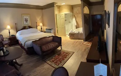 a bedroom with a bed and a couch in a room at Mario's International Spa, Hotel & Restaurant in Aurora