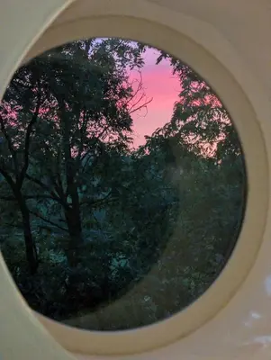a round window with trees in the background at The Grand Landmark 5-Story Windmill Retreat in Lorain