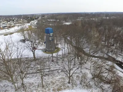 an aerial view of a blue water tower in the snow at The Grand Landmark 5-Story Windmill Retreat in Lorain