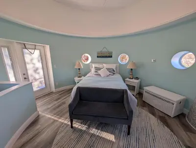 a bedroom with a bed and a chair in it at The Grand Landmark 5-Story Windmill Retreat in Lorain