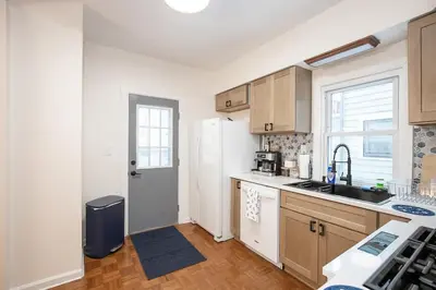 a kitchen with a white refrigerator freezer next to a window at Charming Renovated Home in Lakewood in Lakewood
