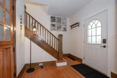 a hallway with a staircase and a white door at Charming Renovated Home in Lakewood in Lakewood