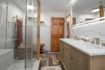 a bathroom with two sinks and a glass shower at Charming Renovated Home in Lakewood in Lakewood