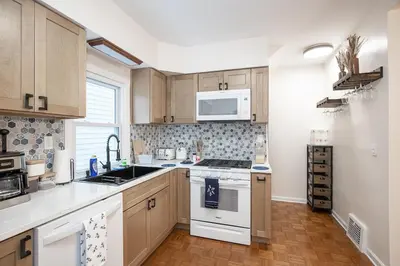 a kitchen with wooden cabinets and a white stove top oven at Charming Renovated Home in Lakewood in Lakewood