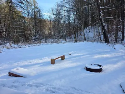 a snow covered field with wooden objects in the snow at Our Place in Nelsonville