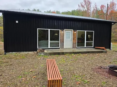 a black building with a bench in front of it at Our Place in Nelsonville