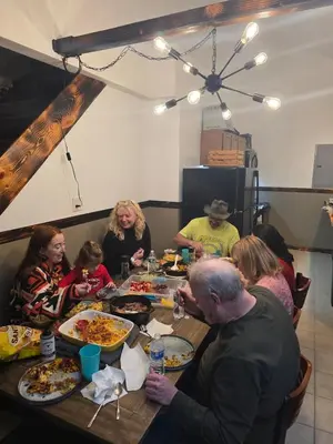 a group of people sitting around a table eating food at Our Place in Nelsonville