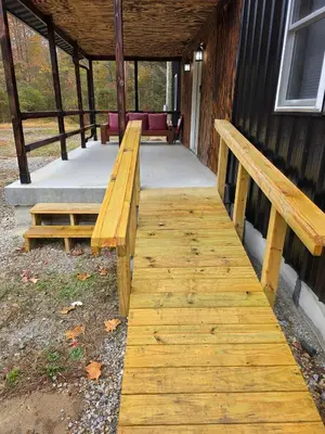 a wooden walkway with two benches on a building at Our Place in Nelsonville