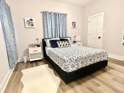 a bedroom with a bed with blue curtains and a window at Newly Remodeled 2 Bedroom Home in Shelbyville Family Friendly in Shelbyville