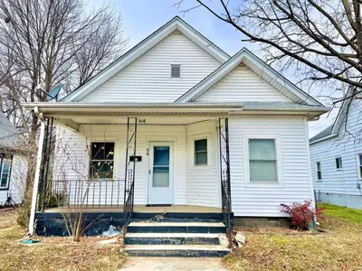 a white house with a gate on the front of it at Newly Remodeled 2 Bedroom Home in Shelbyville Family Friendly in Shelbyville