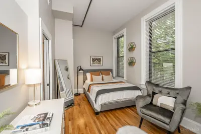 a bedroom with a bed and a chair at Gimme Shelter - OTR Cininnati in Cincinnati