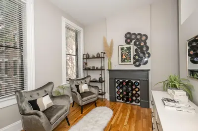 a living room with two chairs and a fireplace at Gimme Shelter - OTR Cininnati in Cincinnati