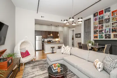 a living room with a couch and a kitchen at Gimme Shelter - OTR Cininnati in Cincinnati