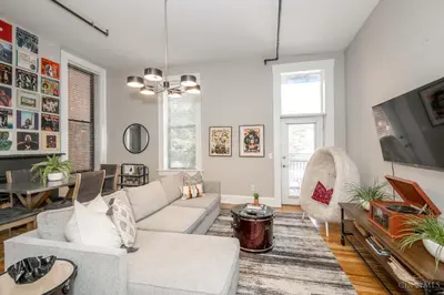 a living room with a couch and a tv at Gimme Shelter - OTR Cininnati in Cincinnati