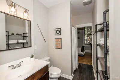 a bathroom with a sink and a toilet and a mirror at Gimme Shelter - OTR Cininnati in Cincinnati