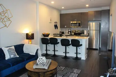 a living room with a couch and a kitchen at Cincinnati Downtown Oasis in Cincinnati