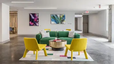 a living room with a green couch and two yellow chairs at Cincinnati Downtown Oasis in Cincinnati