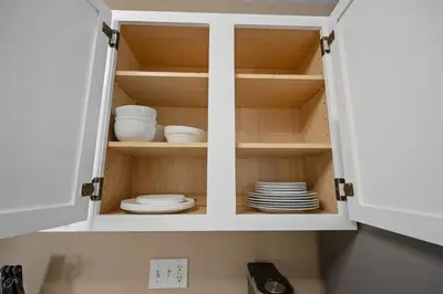 a cupboard with plates and dishes in it at Tusculum Hilltop Haven For 8 in Cincinnati
