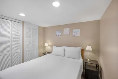 a bedroom with a white bed and two lamps at Tusculum Hilltop Haven For 8 in Cincinnati