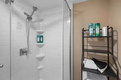 a bathroom with a shower with a glass door at Tusculum Hilltop Haven For 8 in Cincinnati