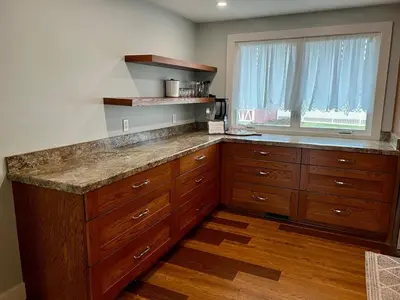 a large kitchen with wooden cabinets and a window at 30 Something Quiet 3BR House Near I-77 & US-250 in New Philadelphia