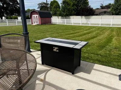 a black trash can sitting on a patio next to a yard at 30 Something Quiet 3BR House Near I-77 & US-250 in New Philadelphia