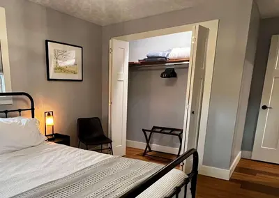 a bedroom with a bed and a chair and a mirror at 30 Something Quiet 3BR House Near I-77 & US-250 in New Philadelphia