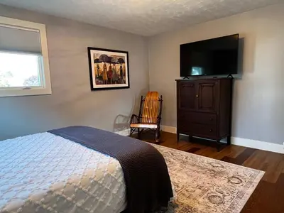a bedroom with a bed and a flat screen tv at 30 Something Quiet 3BR House Near I-77 & US-250 in New Philadelphia