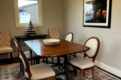 a dining room with a table and chairs and a christmas tree at 30 Something Quiet 3BR House Near I-77 & US-250 in New Philadelphia
