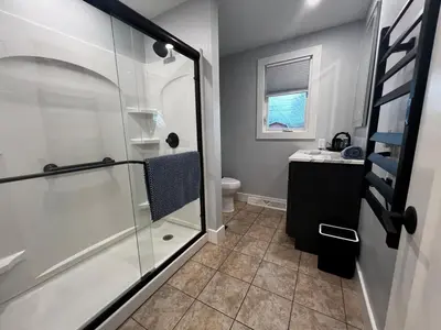 a bathroom with a glass shower and a toilet at 30 Something Quiet 3BR House Near I-77 & US-250 in New Philadelphia
