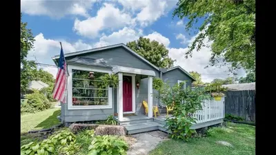 a tiny house with a red door and a flag at Peaceful Cozy 2BR OASIS in Dayton