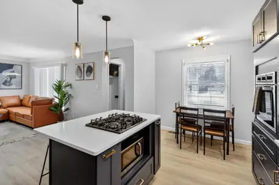 a kitchen and living room with a stove top oven at Stunning Home 15 Min to Downtown & Airport in Parma