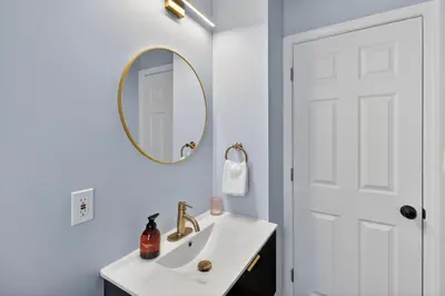 a white bathroom with a sink and a mirror at Stunning Home 15 Min to Downtown & Airport in Parma