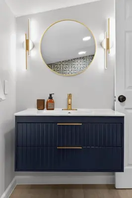 a bathroom with a blue vanity and a mirror at Stunning Home 15 Min to Downtown & Airport in Parma