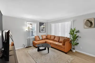 a living room with a brown couch and a table at Stunning Home 15 Min to Downtown & Airport in Parma