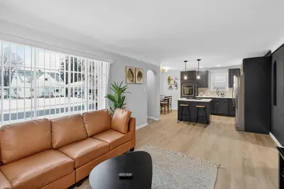 a living room with a couch and a kitchen at Stunning Home 15 Min to Downtown & Airport in Parma