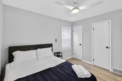 a white bedroom with a bed and a ceiling fan at Stunning Home 15 Min to Downtown & Airport in Parma