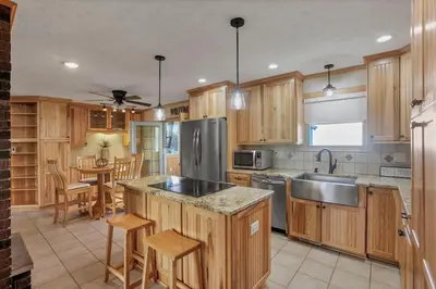 a kitchen with wooden cabinets and a stainless steel refrigerator at The Nook on the Farm with Pool,Hot tub and Games in Pataskala