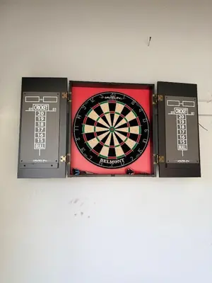 a dart board and three boxes on a wall at The Nook on the Farm with Pool,Hot tub and Games in Pataskala